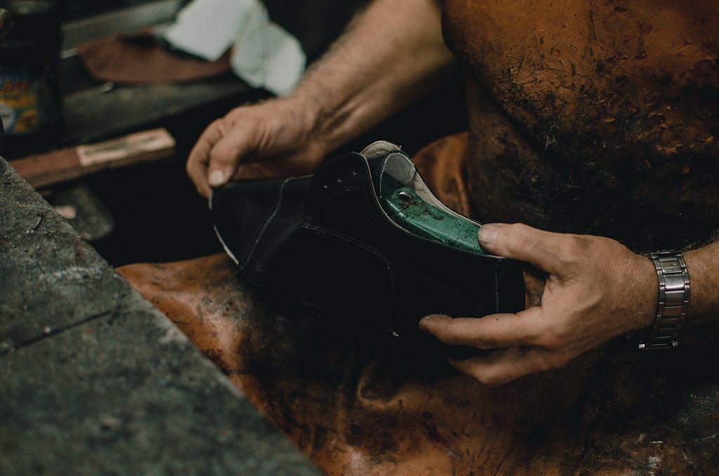 Close-up of an artisan crafting a leather shoe by hand in a workshop.